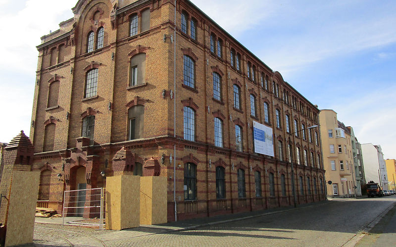 Ansicht des Hauptgebäudes im Bauzustand, eingehauste Torpfeiler, kleiner Blick auf den Hof des Museums, kurze Kurve des Schienenverlaufs für die Schwarze Jule 