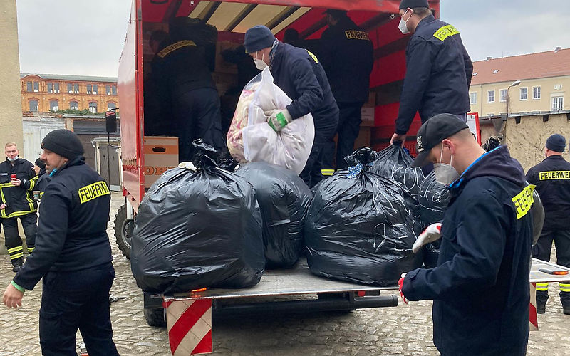 Kameraden der Freiwilligen feuerwehr verstauen die Sachspenden auf einem LKW