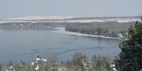 Der Klinger See ist teilweise gefroren, der Landbereich mit Schnee bedeckt