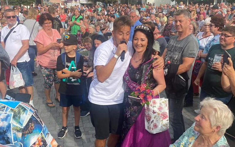 in der Bildmitte ist die Forster Rosenkönigin Jacqueline I. mit Alexander Knappe, einem Cottbuser Künstler zusehen, umgeben von vielen Gästen des Brandenburgtages