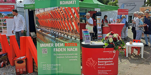Zu sehen ist der Informationsstand der Stadt Forst (Lausitz) mit Aufstellern zur Stadt und zu touristischen Zielen wie dem Ostdeutschen Rosengarten, das zu Zeit neu entstehende Museum, bzw. mit Informationen über die Stadt