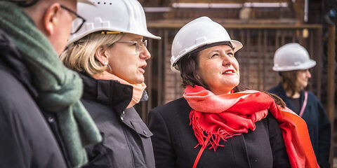 von links nach rechts zu sehen sind Teamleiter Museum Jörn Brunotte, Projektleiterin Bauabwicklung Stadt Forst (Lausitz) Nadine Schmidt, Kulturministerin des Landes Brandenburg Manja Schüle, die Personen tragen einen Arbeitsschutzhelm und schauen auf ein nicht zu sehendes Objekt auf der Baustelle