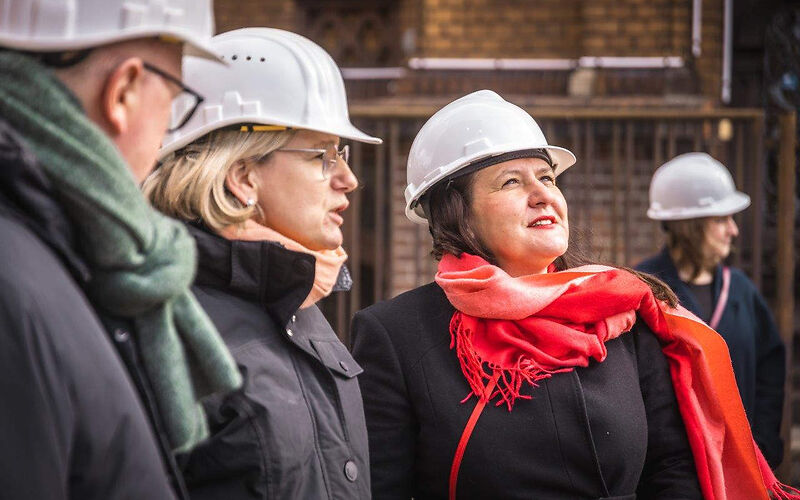 von links nach rechts zu sehen sind Teamleiter Museum Jörn Brunotte, Projektleiterin Bauabwicklung Stadt Forst (Lausitz) Nadine Schmidt, Kulturministerin des Landes Brandenburg Manja Schüle, die Personen tragen einen Arbeitsschutzhelm und schauen auf ein nicht zu sehendes Objekt auf der Baustelle