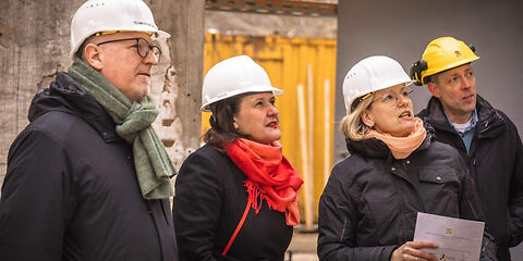 von links nach rechts  zu sehen sind Teamleiter Museum Jörn Brunotte,  Kulturministerin des Landes Brandenburg Manja Schüle, Projektleiterin Bauabwicklung Stadt Forst (Lausitz) Nadine Schmidt, Leiter des Eigenbetriebes Kultur, Tourismus, Marketing Rosenstadt Forst (Lausitz) Stefan Palm, alle Personen tragen einen Arbeitsschutzhelm und schauen auf ein nicht zu sehendes Ojekt auf der Baustelle