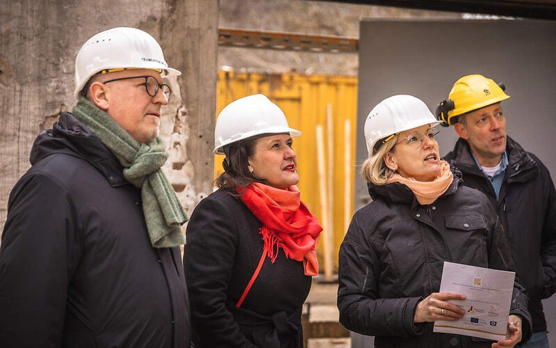 von links nach rechts  zu sehen sind Teamleiter Museum Jörn Brunotte,  Kulturministerin des Landes Brandenburg Manja Schüle, Projektleiterin Bauabwicklung Stadt Forst (Lausitz) Nadine Schmidt, Leiter des Eigenbetriebes Kultur, Tourismus, Marketing Rosenstadt Forst (Lausitz) Stefan Palm, alle Personen tragen einen Arbeitsschutzhelm und schauen auf ein nicht zu sehendes Ojekt auf der Baustelle