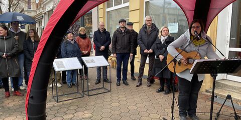 Eine Frau spielt Gitarre und singt dazu.