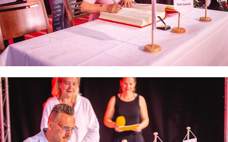 oben: Frau Beata Kowalczuk, Bürgermeisterin von Brody, sitzt an einem mit einem weißen Tischtuch gedeckten Tisch, auf dem das goldene Buch der Stadt Forst (Lausitz) aufgeschlagen liegt. Hinter ihr stehen u. a. der Vorsitzende der Stadtverordnetenversammlung Ingo Paeschke und die Bürgermeisterin von Forst Simone Taubenek.; unten: Herr Janusz Dudojć (Bürgermeister von Lubsko) sitzt an einem mit einem weißen Tischtuch gedeckten Tisch, auf dem das goldene Buch der Stadt Forst (Lausitz) aufgeschlagen liegt. Vorn auf dem Tisch stehen die Wappen der Städte Forst (Lausitz), Lubsko und Brody.