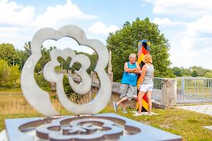 Grenzrose in der Nähe des Seufzersteges am Radwanderweg, Fotograf: PatLografie, Patrick Lucia, Copyright: Stadt Forst (Lausitz) Grenrose, stilisierte Blüte aus Edelstahl auf einem Sockel, in der Nähe des Seufzersteges, Ruine einer Fußgängerbrücke über die Neiße am Radwanderweg
