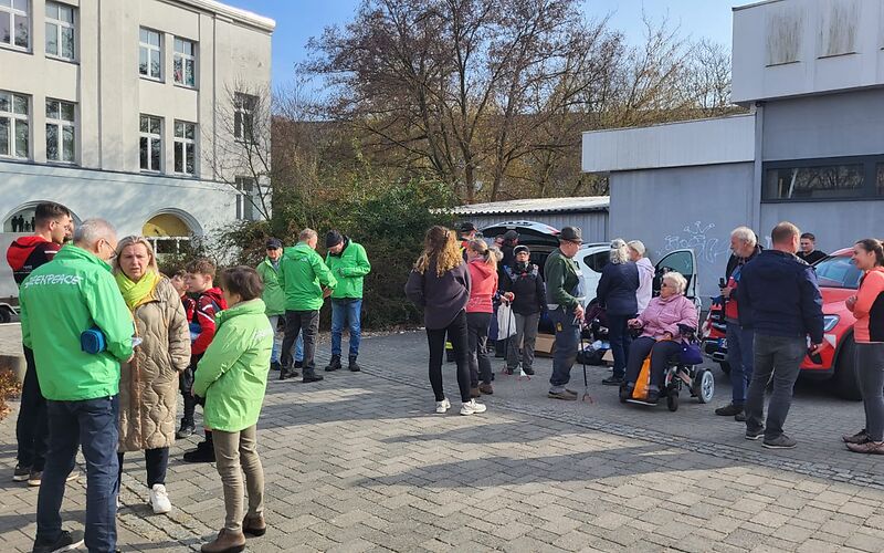 Eine Gruppe Personen, einige mit grünen Greenpeace-Jacken, auf dem Max-Saydewitz-Platz.