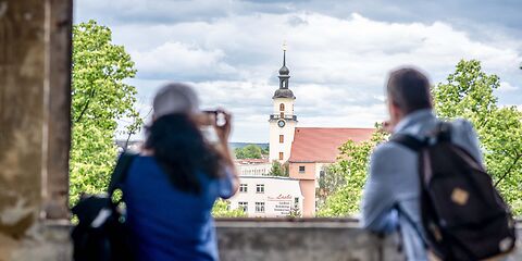 Eine Frau und ein Mann schauen sich die St. Nikolaikirche vom Fenster der Gründer- und Traumfabrik in Forst (Lausitz) an.