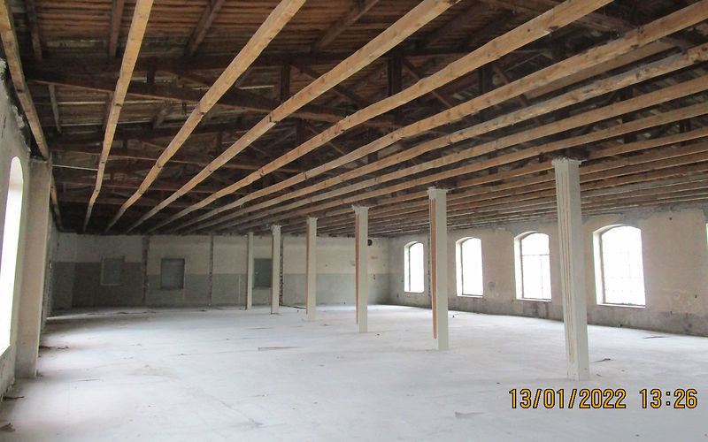 Blick in die leere Fabriketage. Alle nicht tragenden Wände sind zurück gebaut. Die Unterhangdecke ist abgebrochen. Man sieht  die Dachbalken und die Schalung.