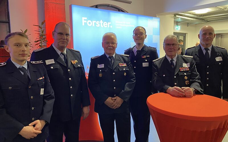 Männliche Vertreter der Feuerwehr in dunklen Uniformen