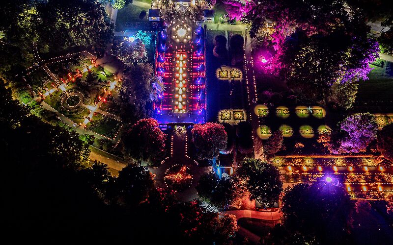 Blick von oben auf den Rosengarten in Forst bei Nacht – farbenfrohe Lichtilluminationen während der Rosengartenfesttagen leuchten thematische Gartenbereiche aus.