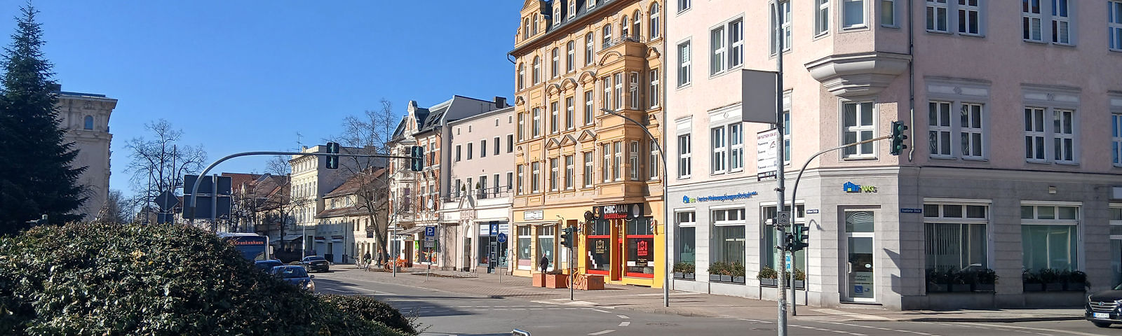 Straßenszene mit mehrstöckigen historischen Gebäuden und einem blauen Himmel