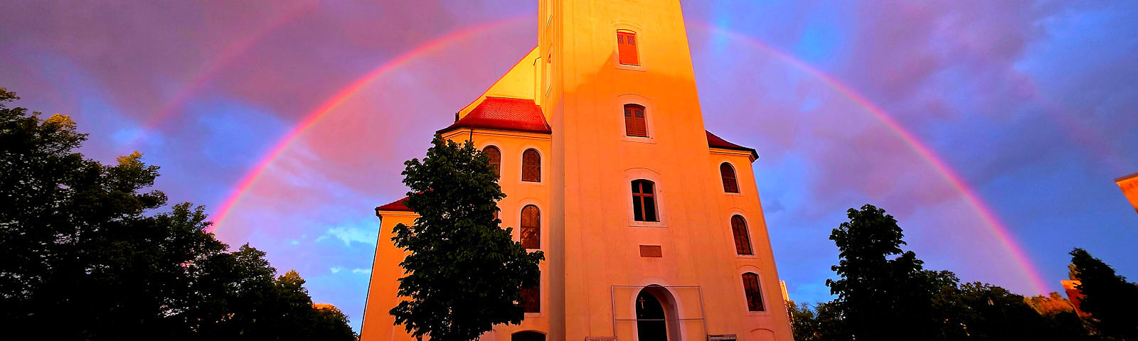 Ein Regenbogen im Halbkreis vor der Stadtkirche St. Nikolai.
